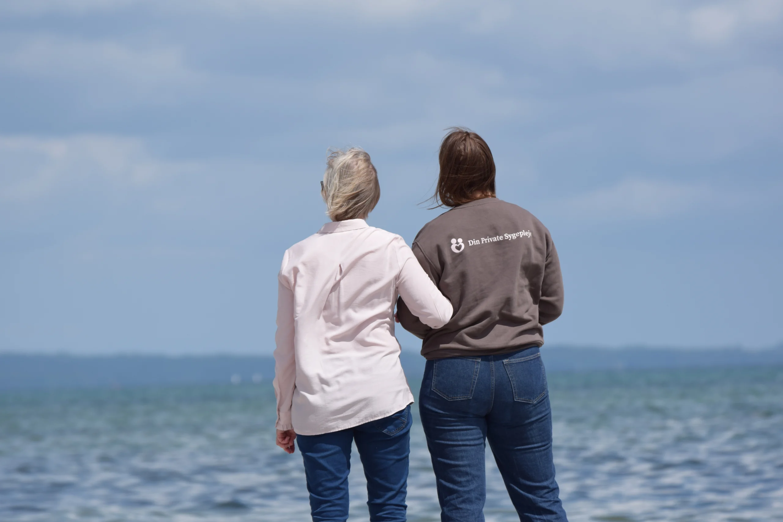 Patient og sygeplejerske står ved havet og nyder udsigten